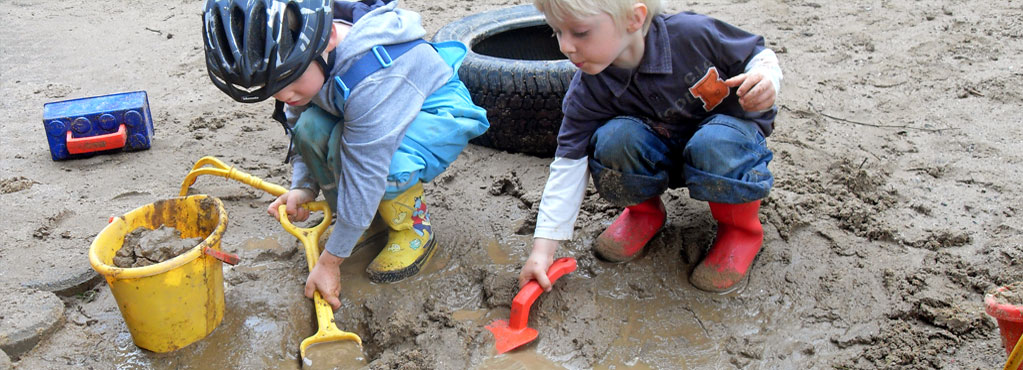 Bild 2 zeigt 2 spielende Kinder im Sandkasten.