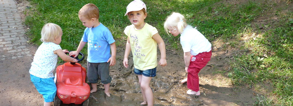 Bild 6 zeigt Kinder die draußen im Matsch spielen.